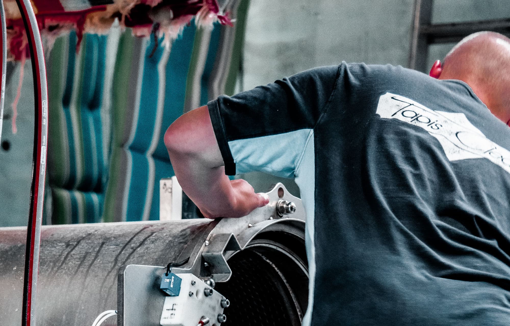 A Tapis Clean technician at the washing station, working on a rug